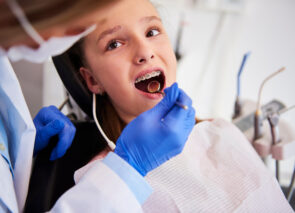 ילדה עם גשר בשיניים בביקור אצל רופאת שיניים