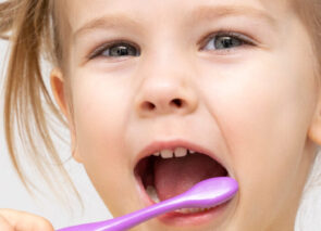 ילדה מצחצחת שיניים