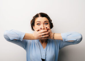אישה מכסה את הפה עם הידיים